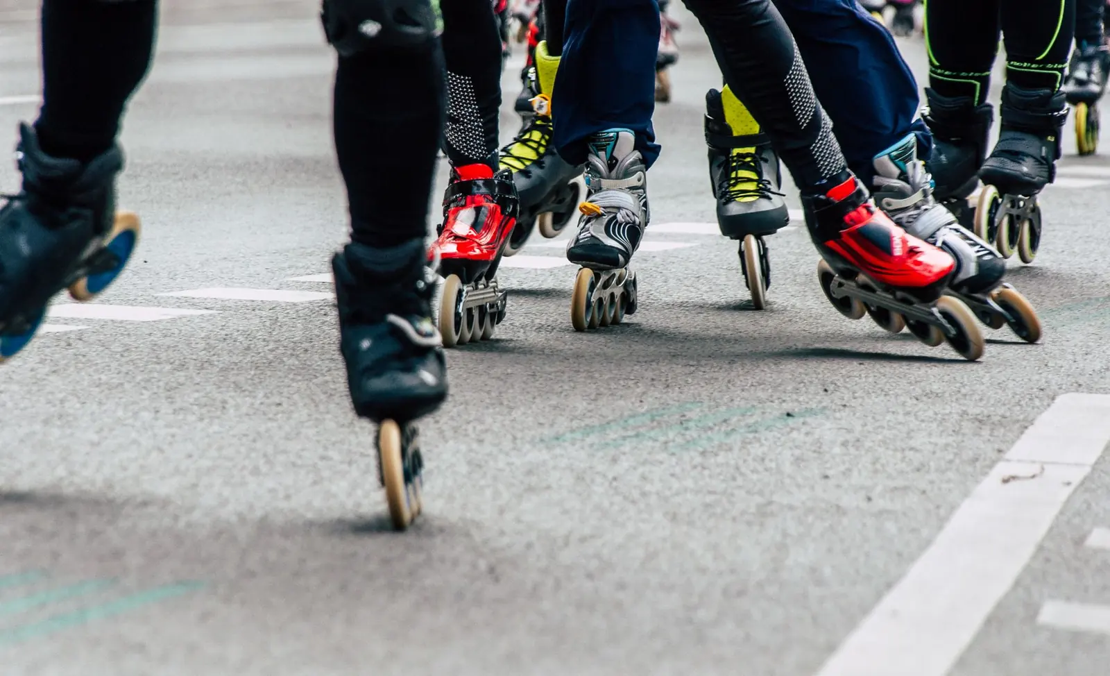 Grupo de patinadores en línea rodando juntos por la calle